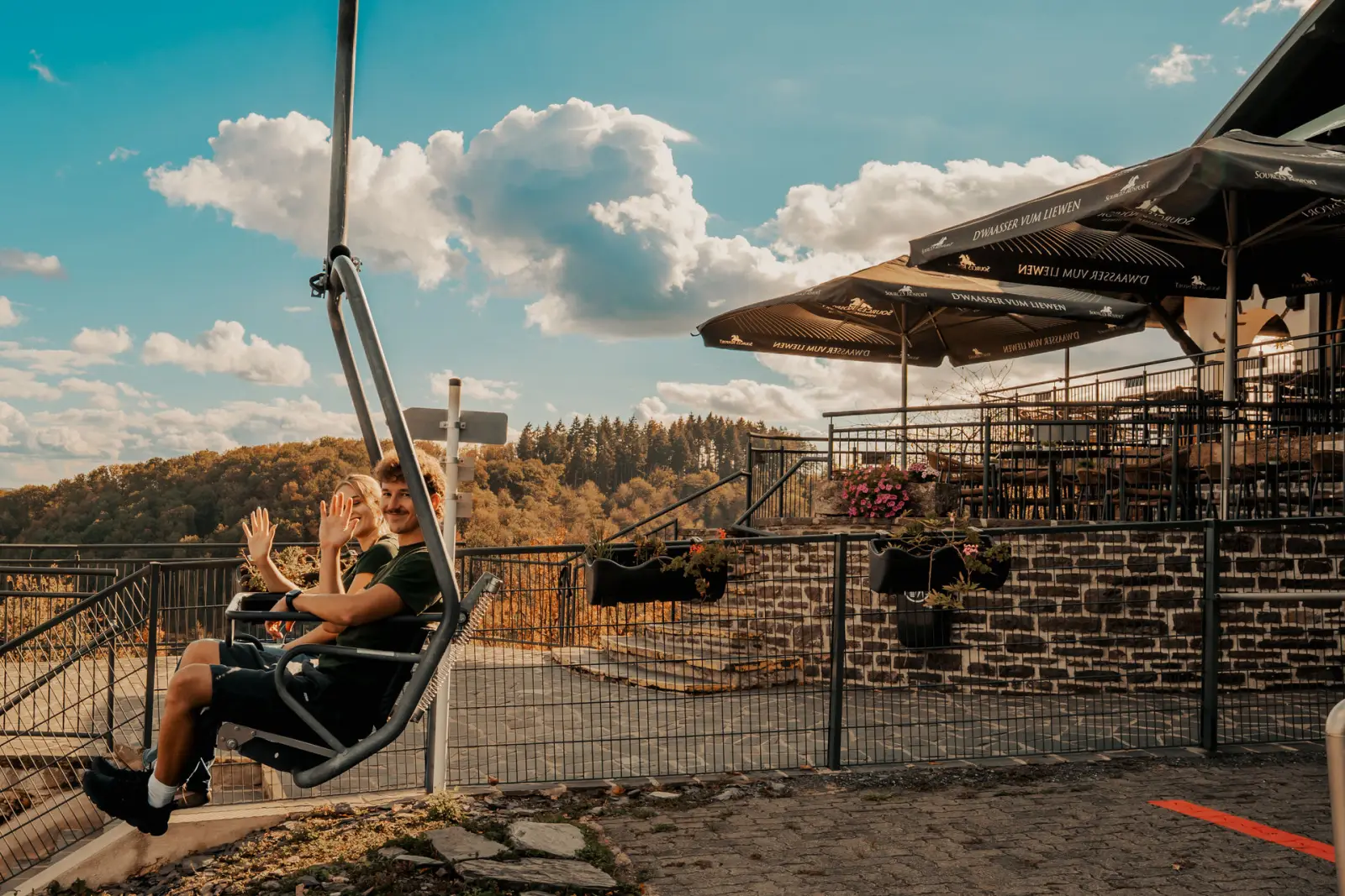 Gäste im Sessellift vor der Terrasse