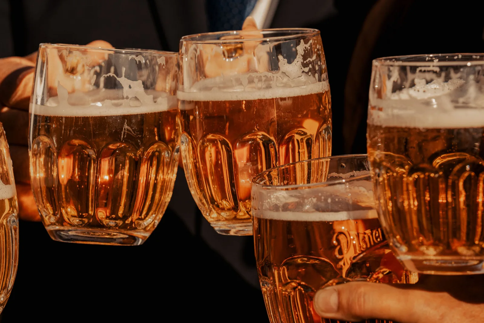 Anstoßen mit frisch gezapftem Pilsner Urquell